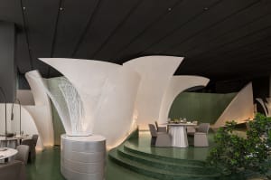 Elegant dining space with a white dome structure, minimalist design, and a dining table with chairs and wine glasses