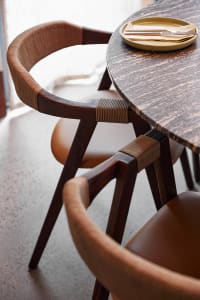 A warm and inviting dining space with a wooden table surrounded by two chairs, perfect for enjoying meals together