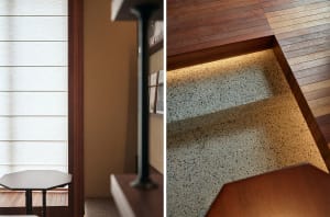 Cozy living area with wooden floors, a dining table, and a staircase leading to another level