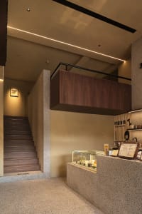 Open living area with wooden floors and walls, featuring a combined kitchen, dining, and living space with comfortable seating and a dining table