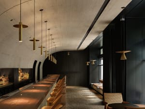 A cozy bar area with a long wooden counter and multiple chairs, creating a warm and inviting atmosphere