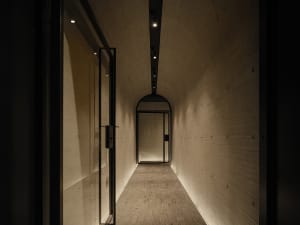 Empty hallway with a wooden floor, a door, and a calm atmosphere