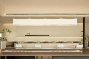 A clean and well-organized restaurant with white walls, numerous dining tables, and chairs, ready for customers