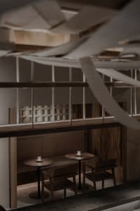 Cozy restaurant interior with wooden tables, metal elements, and warm ambiance from candles