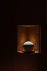 A cozy home interior with a ceramic vase on a brown surface, suggesting a warm and inviting atmosphere
