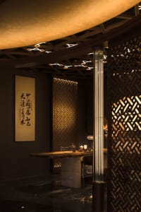Warm and inviting Asian restaurant interior with a wooden dining table, chairs, and traditional design elements