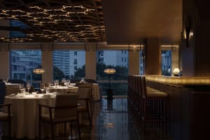 Sophisticated dining space with wooden accents, well-lit surroundings, and wine glasses on tables