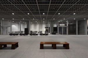 A spacious restaurant with multiple dining tables and chairs, featuring wood elements and a warm atmosphere