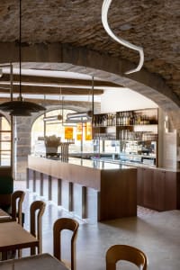 A restaurant interior with a bar area, dining tables, and comfortable seating for patrons
