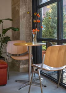 Warm and inviting dining area with a wooden table, two chairs, and a vase with flowers