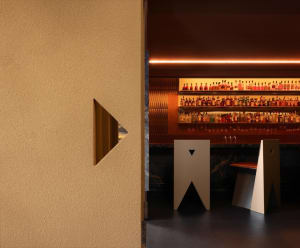 Inviting bar area with a long wooden counter, wine glasses, and a nearby dining table