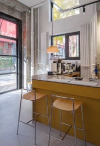 A warm kitchen with wooden countertops and cabinets, featuring two chairs for seating and a well-equipped layout for cooking and dining
