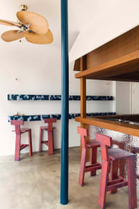 A warm and inviting bar area with wooden tables, chairs, and a distinctive bar counter, perfect for socializing and enjoying drinks