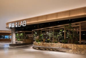 A cozy indoor space with potted plants, dining tables, and chairs, creating a welcoming atmosphere for customers
