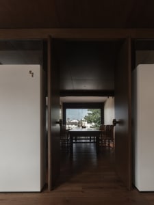 Cozy dining area with wooden table and chairs, dimly lit, and warm wood flooring