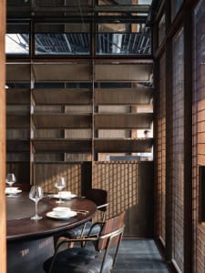 Warm and inviting dining area with a wooden table, chairs, and wine glasses, set for social gatherings