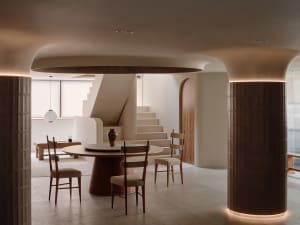 Open living area with dining table, chairs, couch, and kitchen cabinets in a well-designed interior space with comfortable and inviting atmosphere