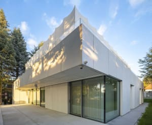 A modern building with a glass front, large windows, and a clean, minimalist design, allowing ample natural light to enter the interior spaces