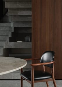 A warm and inviting dining space with a wooden chair, dining table, and scattered books, situated near a doorway