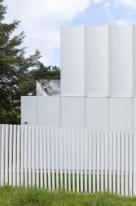 A modern building with a concrete exterior, surrounded by trees and greenery, creating a serene environment