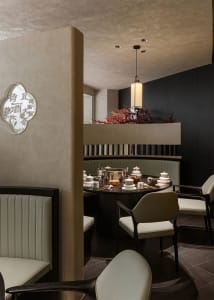 Elegant dining area with tables, chairs, and multiple cups, set for guests in an Asian restaurant