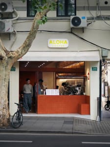 A modern cafe with a warm atmosphere, featuring wood and metal elements, natural light, and a spacious layout with seating and dining areas