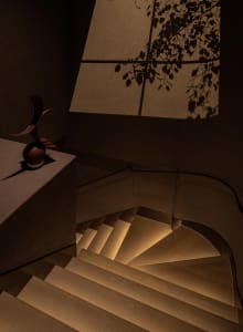 A warm and inviting interior space with a wooden staircase, suggesting a cozy and welcoming atmosphere