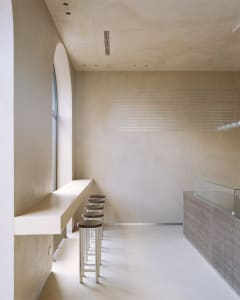 Bright modern restaurant interior with a large window, chairs, and a contemporary dining area