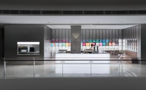 A coffee shop with a counter and a display of drinks, featuring a person standing nearby