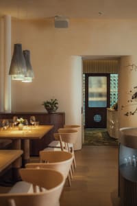 Warm and inviting restaurant interior with dining area, bar, and wine glasses, featuring a comfortable atmosphere for guests