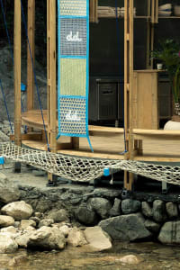 A serene outdoor space with a wooden deck, hammock, and two chairs, perfect for relaxation