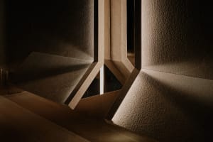 A modern hallway with two doors, one open to a brightly lit area and the other closed, creating a contrast between light and dark