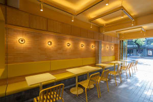 Warm and inviting restaurant interior with yellow walls, brick accents, and dining tables and chairs
