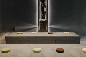 A kitchen counter with three cakes and four donuts displayed in an inviting and appetizing manner
