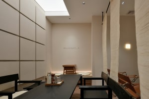 Inviting restaurant interior with multiple tables, chairs, cups, and bottles, and ample seating options
