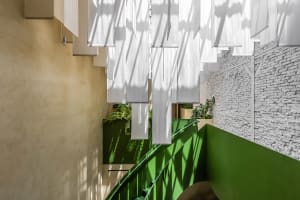A bright and inviting space with a staircase leading to a green area, featuring white curtains and a sense of elegance
