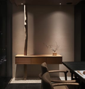 A warm and inviting interior space with a wooden table, two chairs, and natural light from windows