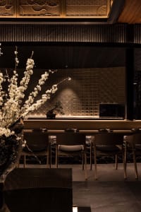 Warm and inviting restaurant interior with wooden tables, chairs, and potted plants
