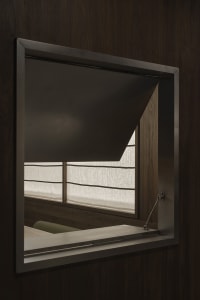A well-lit room with a wooden table and chair, curtains, and natural light from a window