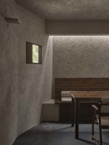 A modern dining area with a wooden table and chairs, well-lit with natural light