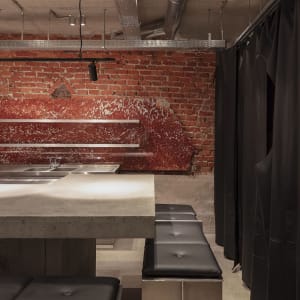 Modern restaurant bar with marble countertop, brick walls, and industrial-chic decor