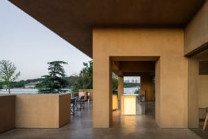 Open-air living area with a stone wall, chairs, and a relaxed atmosphere
