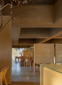 Modern restaurant interior with wooden elements, glass surfaces, and comfortable seating for guests