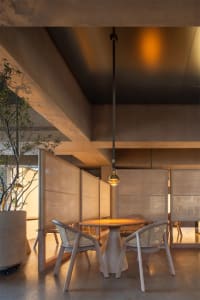 A modern dining area with a large wooden table surrounded by multiple chairs in a warm and inviting atmosphere