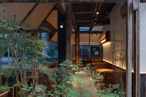 Dimly lit Asian restaurant with wooden floors, walls, and furniture, featuring a mix of wood and bamboo elements