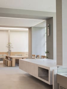 Empty room with a central countertop, chairs, and a dining table, exuding a calm and inviting atmosphere with a focus on functionality and comfort