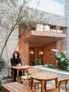 Dining area with multiple tables and chairs, wooden tables, metal chairs, and a comfortable atmosphere