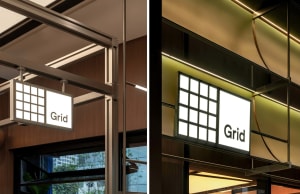A well-lit office space with wooden walls, large windows, and artificial lighting, featuring a sign on display