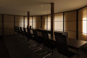 A warm and inviting restaurant dining area with a wooden table surrounded by chairs, creating a comfortable space for guests to enjoy their meals