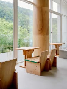 A modern dining area with wooden tables and chairs, inviting atmosphere, and comfortable seating
